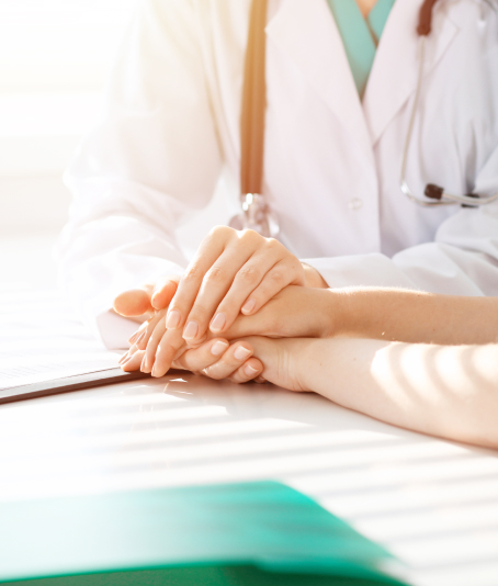 Doctor holding hands with a patient, offering comfort and support