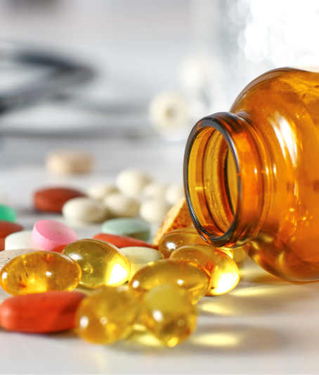 Medicine bottle with various pills spilling out onto a surface